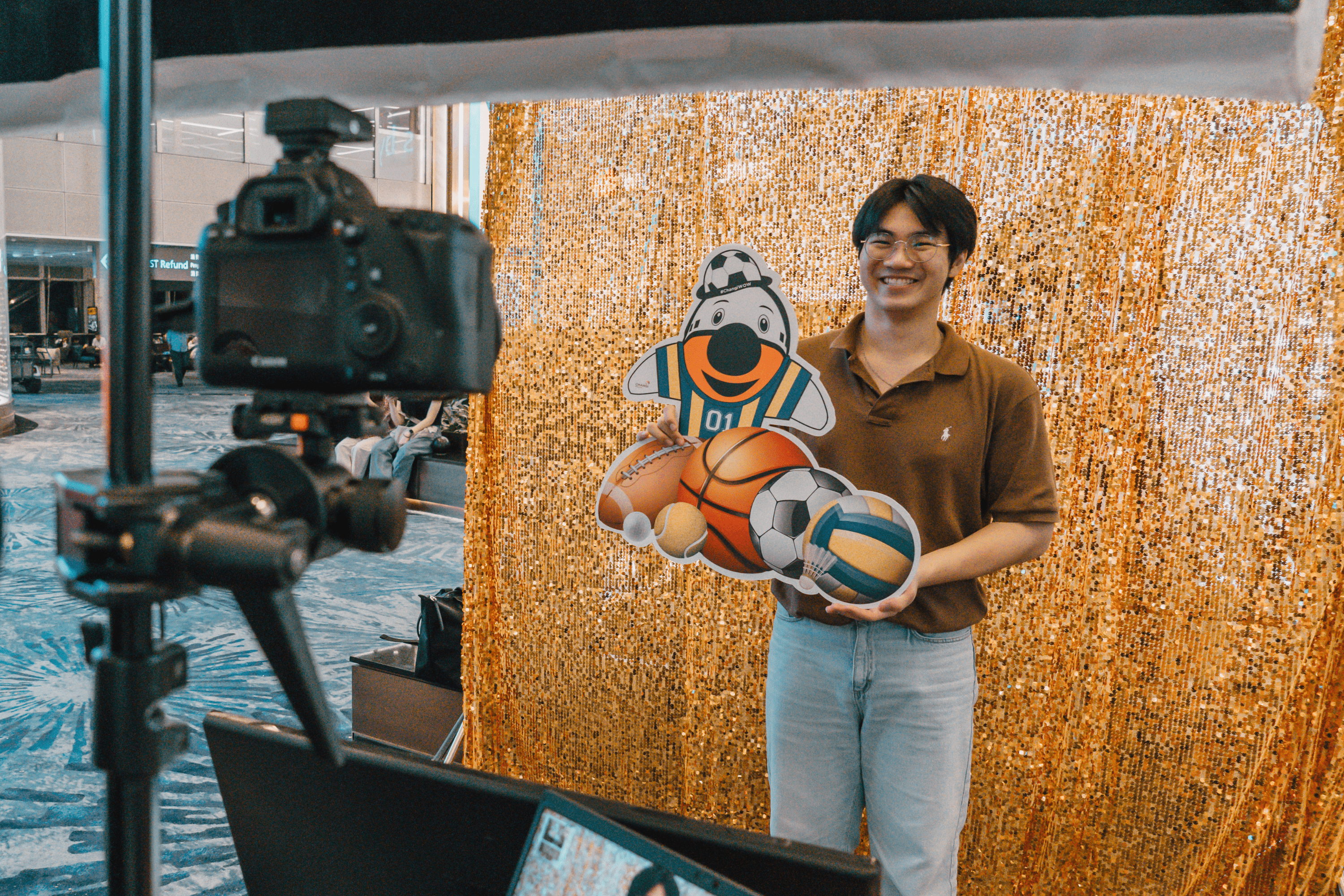 Traveller posing at a photobooth with sport cutouts