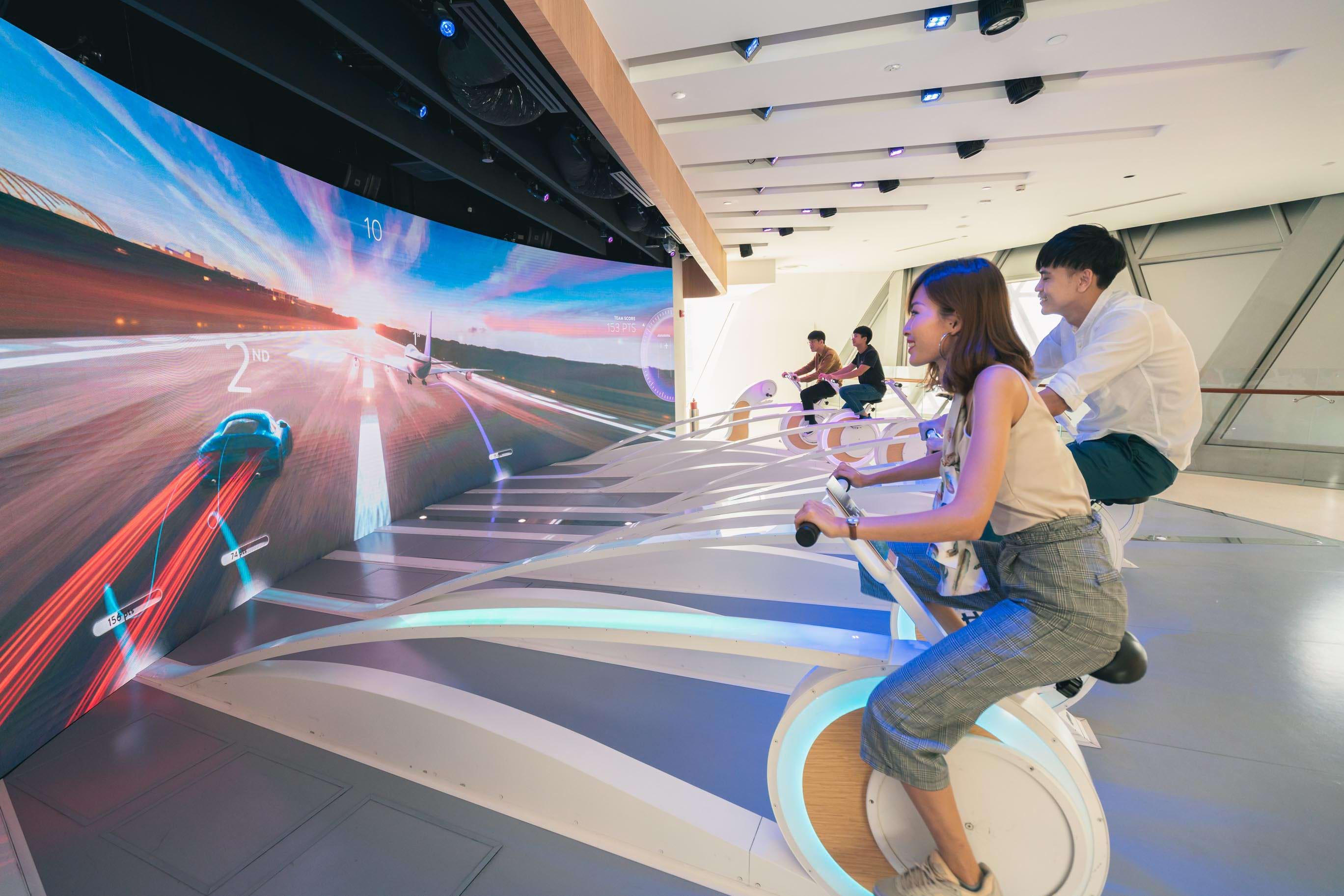 A group of four youths are experiencing the Runway attraction in the Changi Experience Studio in Jewel Changi Airport.